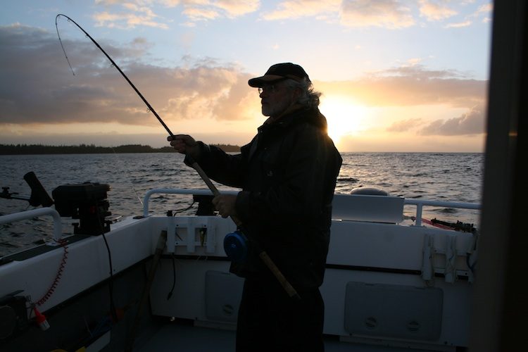 An angler fishing from a boat at sunset off Haida Gwaii